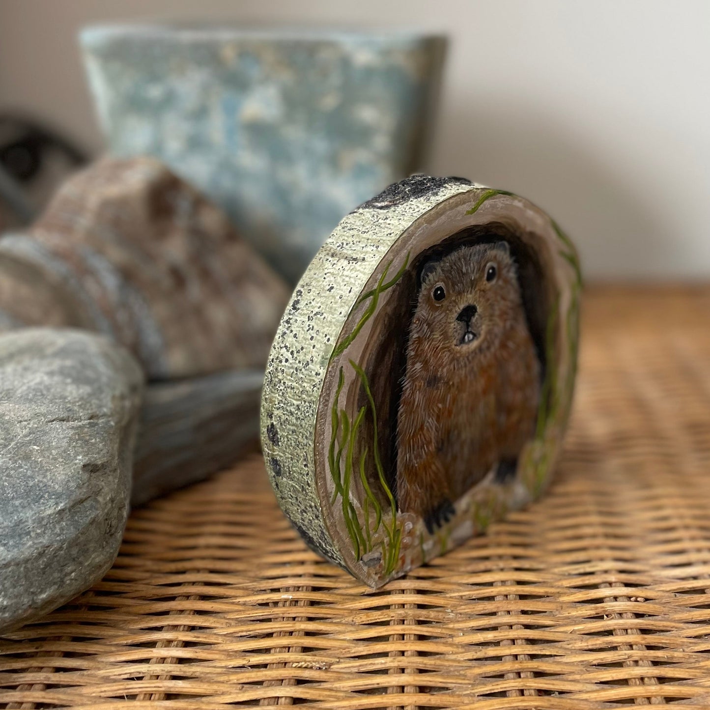 Painting of a Groundhog woodchuck looking out from its burrow