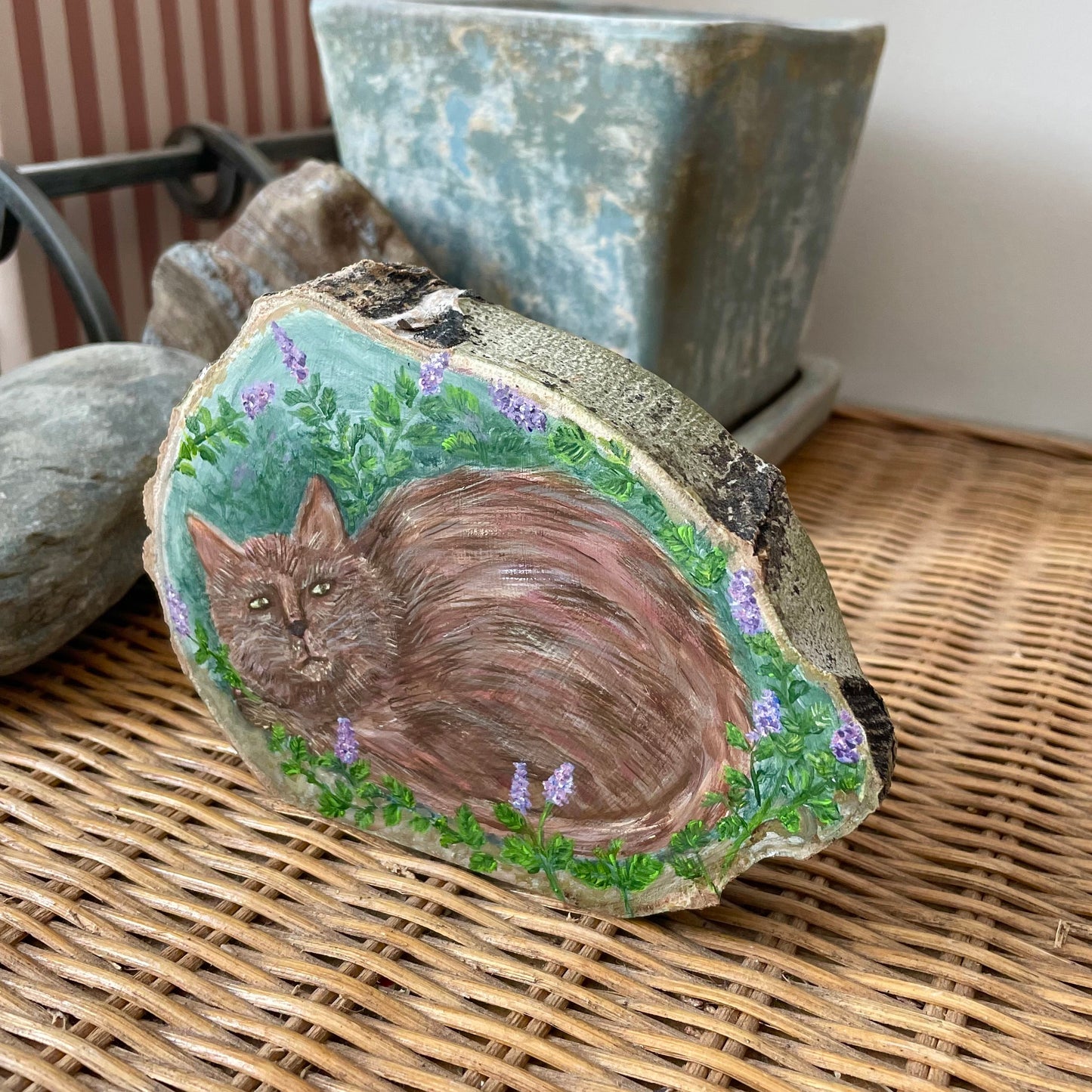 Painting of a cat in a catnip garden on a freestanding aspen wood slice with bark framing the outer edges