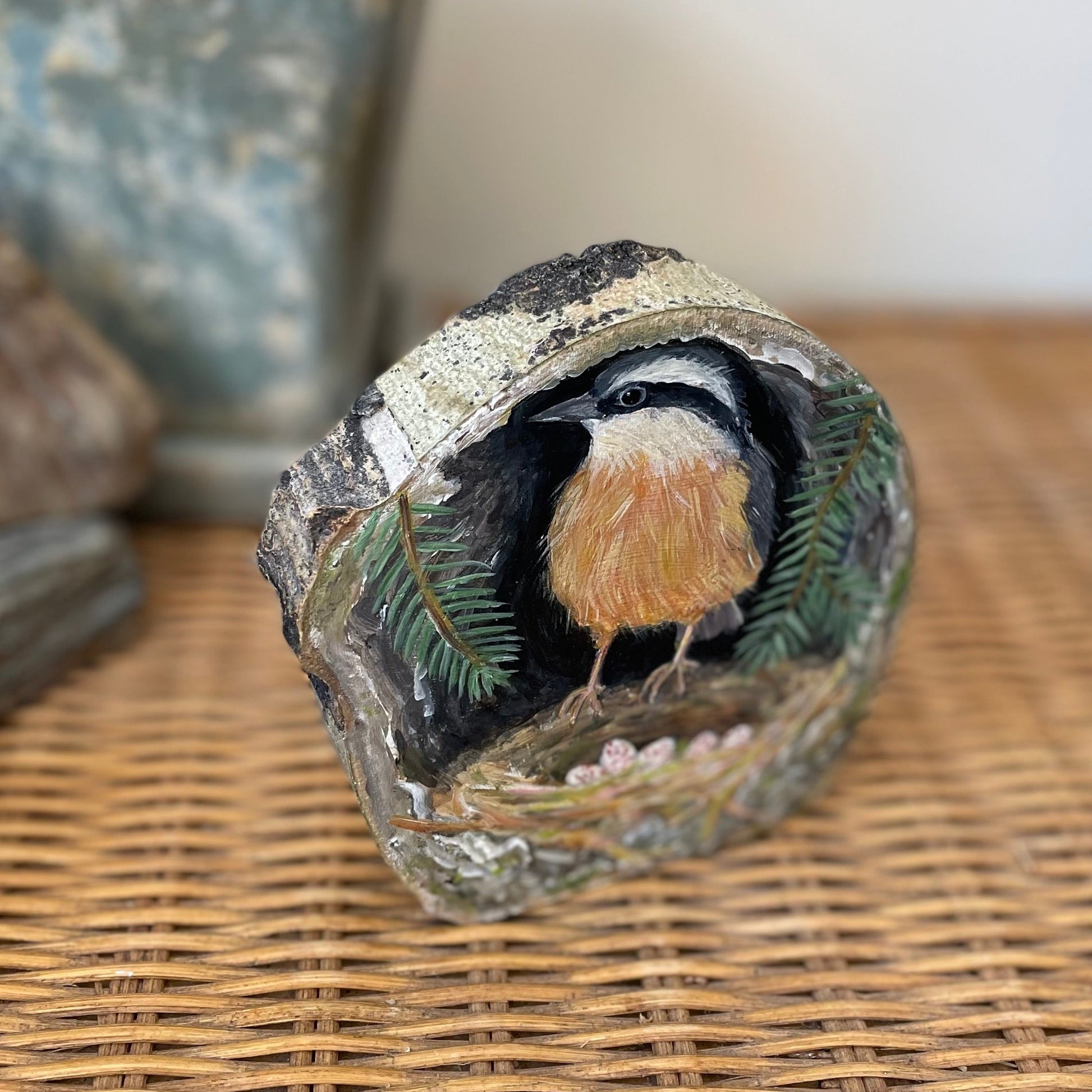 Painting of a red breasted nuthatch in a nest inside a tree cavity on aspen wood 