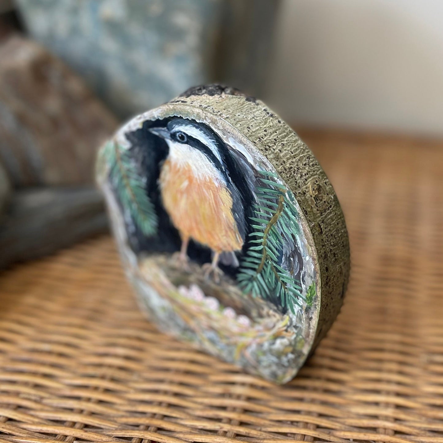 Painting of a red-breasted nuthatch on freestanding aspen wood slice with bark framing the outside 