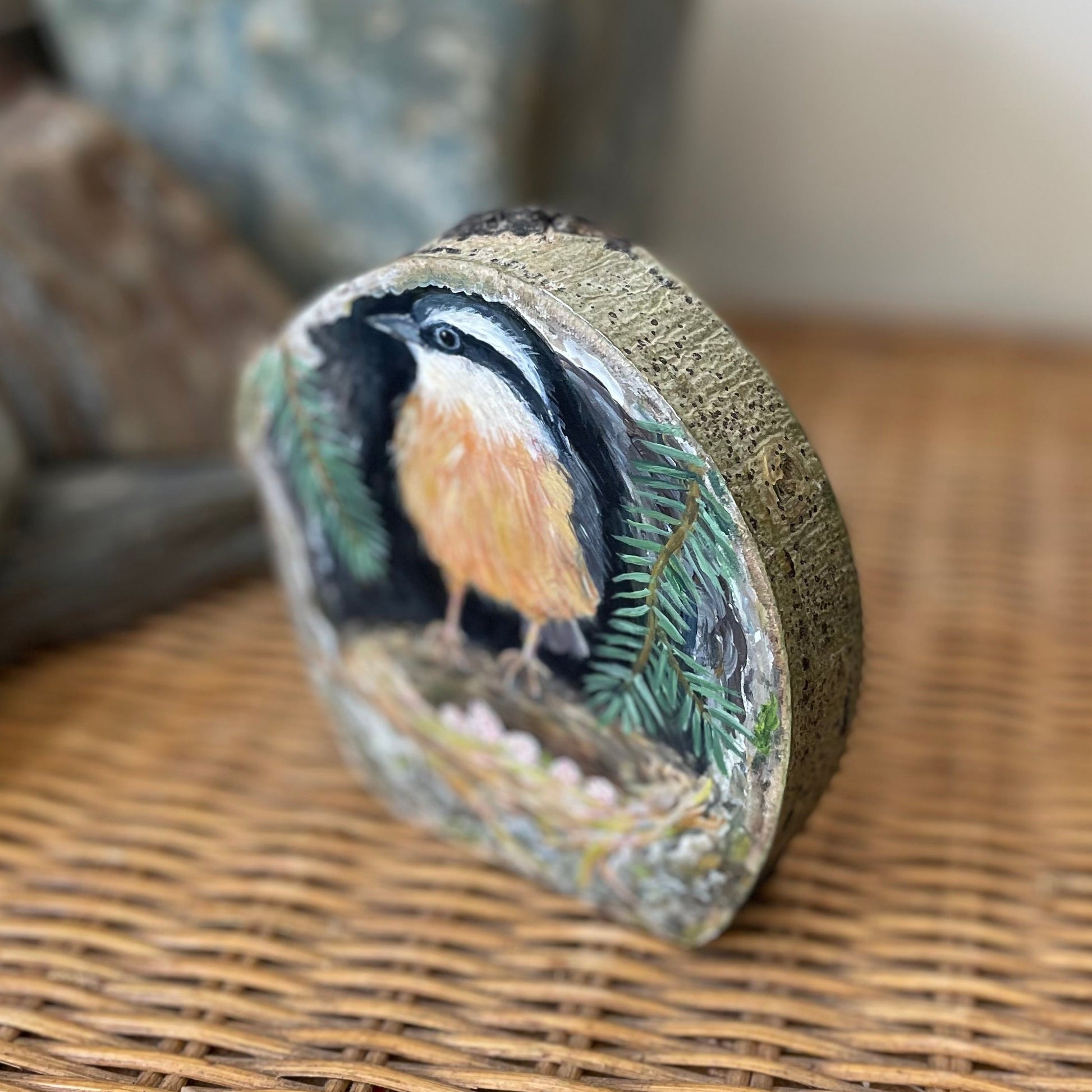 Painting of a red-breasted nuthatch on freestanding aspen wood slice with bark framing the outside 